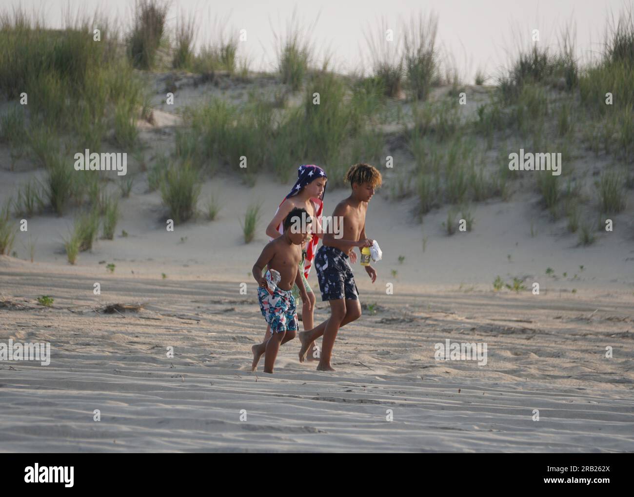 Rehoboth Beach, Delaware, U.S.A - 18 giugno 2023 - tre bambini camminano sulla sabbia vicino alle dune della spiaggia Foto Stock