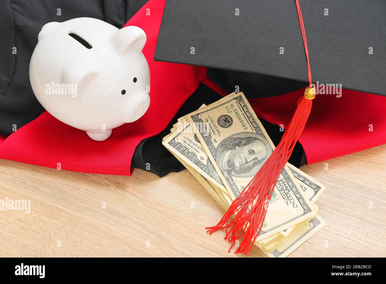 Salvadanaio, banconote in dollari, cappello di graduazione e abito