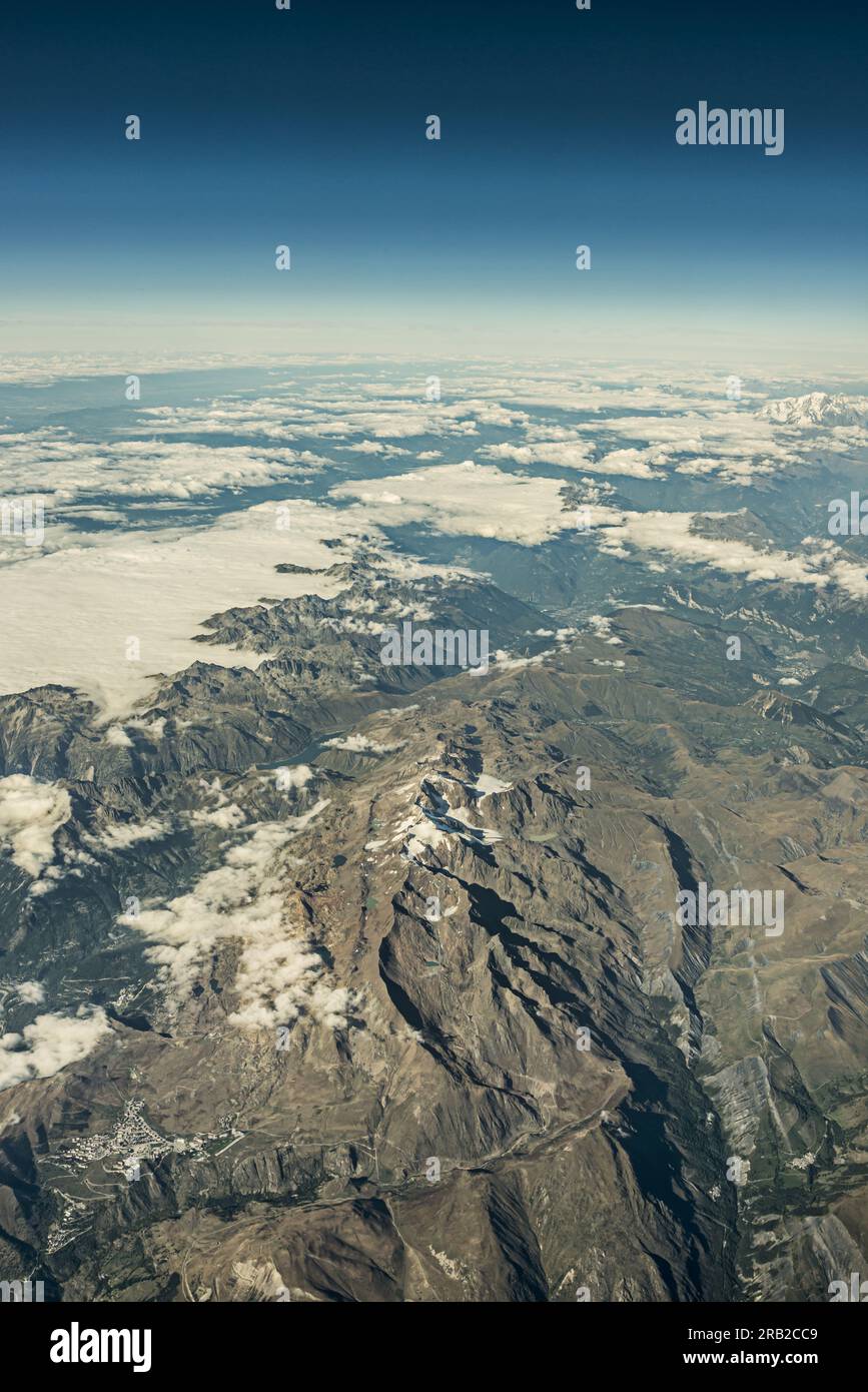 Foto aerea di una catena montuosa con grandi agglomerati di nuvole sulle cime Foto Stock