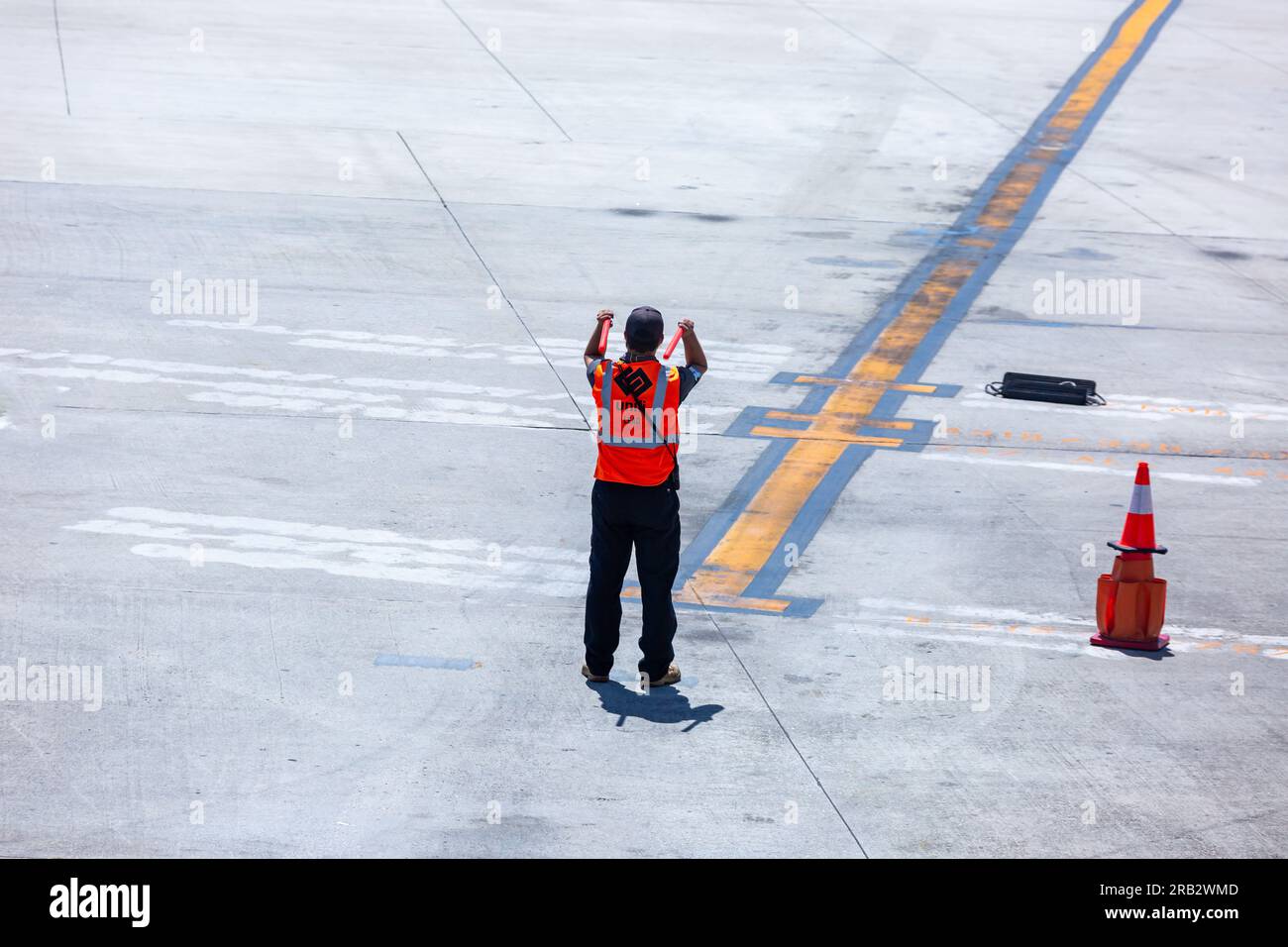 Un marshaler Unifi Aviation Services dirige un aereo in una posizione di parcheggio presso l'aeroporto internazionale di Myrtle Beach, SC, USA. Foto Stock