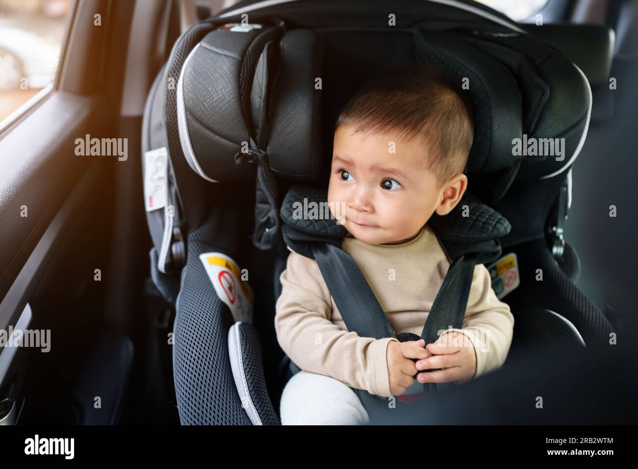 il bambino è sempre pronto a sedersi sul seggiolino per auto e a guardare fuori dalla finestra, mentre la sedia di sicurezza è in movimento Foto Stock