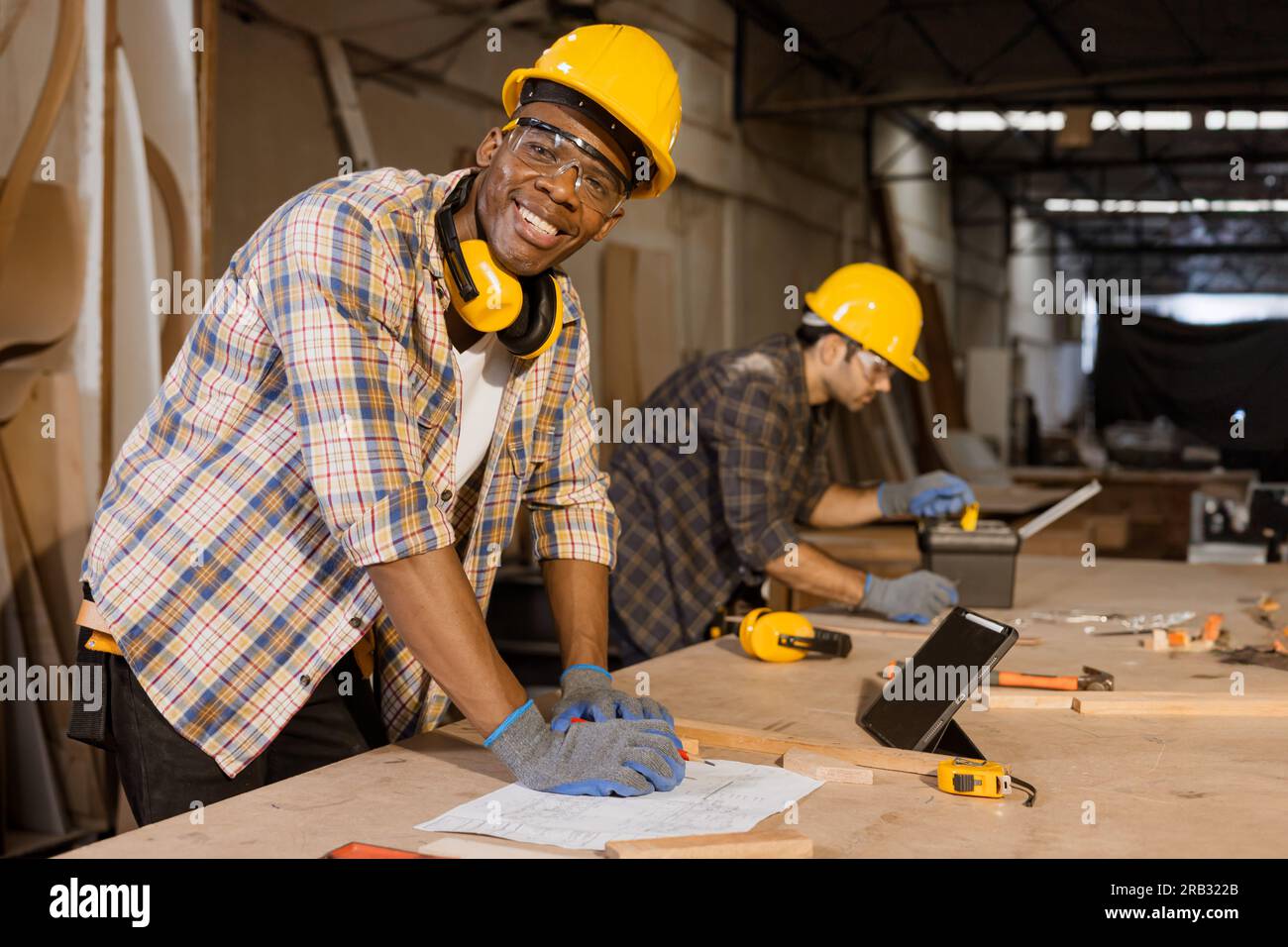 Uomini africani lavoratore felice personale dei produttori di mobili in legno, team di uomini di lavoro in cantiere di pannelli in legno. Foto Stock