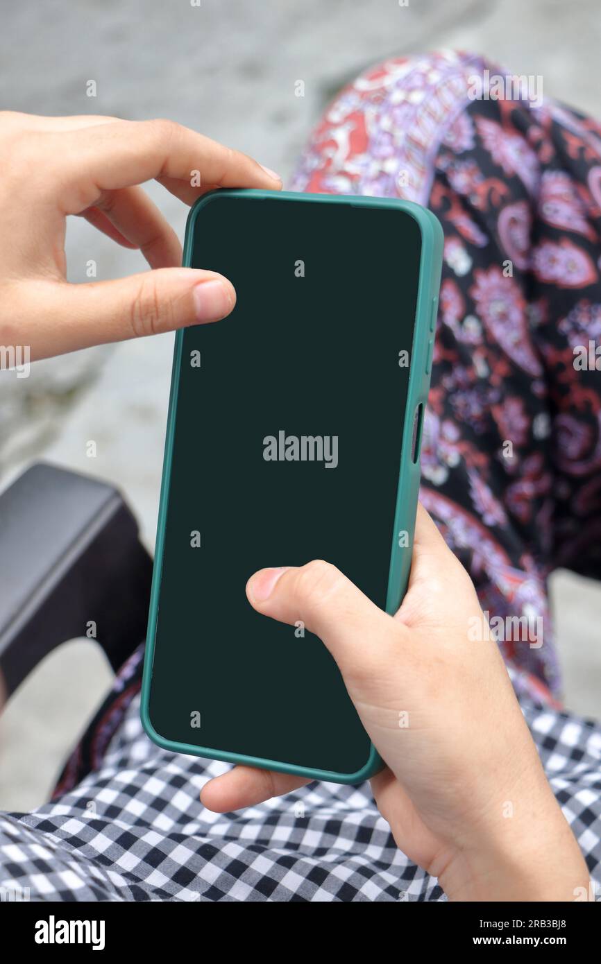 La mano di una ragazza che tiene un cellulare. Foto Stock