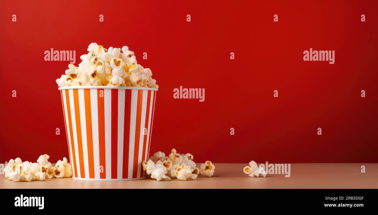 secchiello per popcorn cinematografici su sfondo rosso. striscione con spazio per la copia Foto Stock