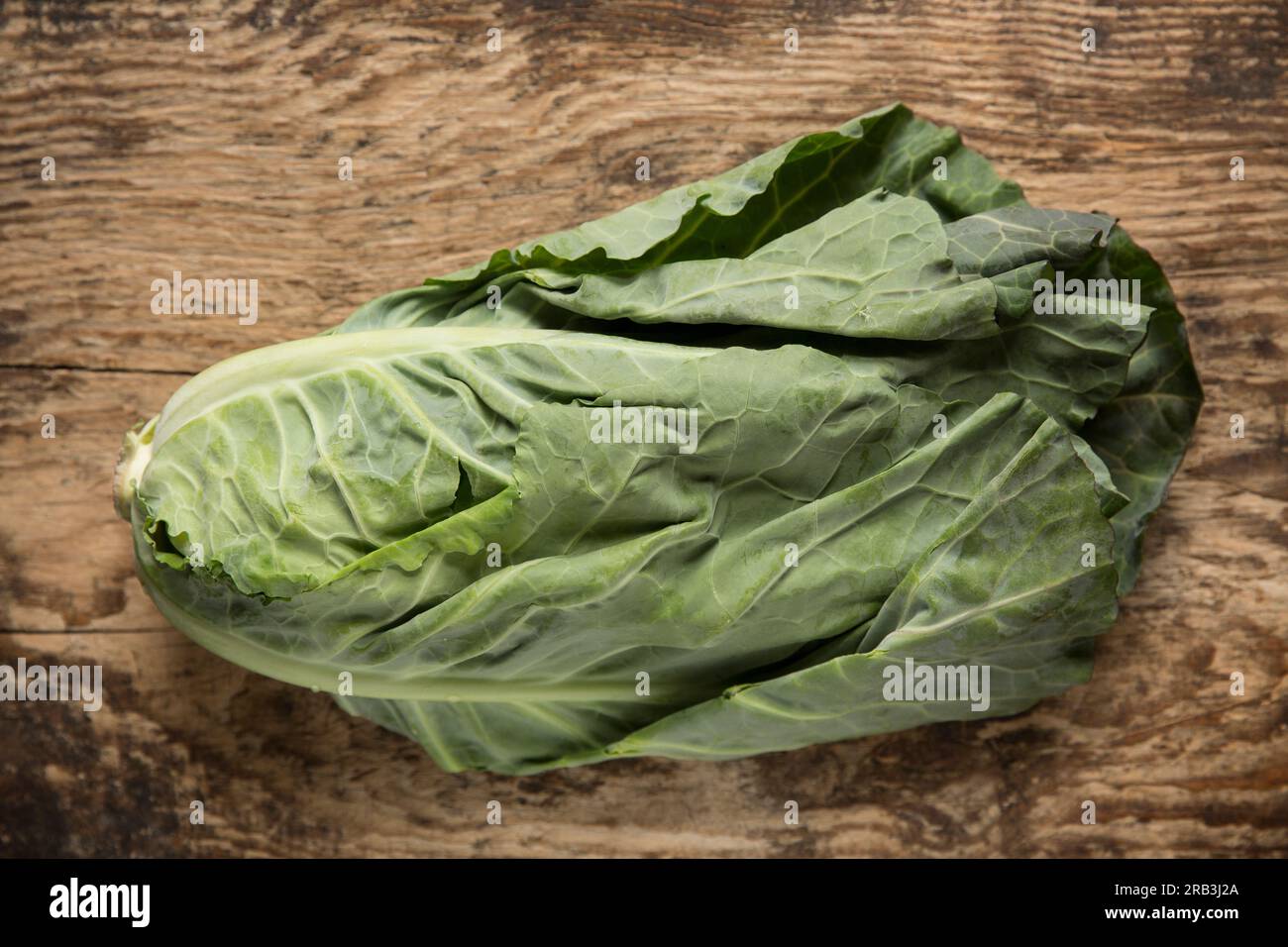 Verdure primaverili britanniche acquistate da un supermercato ed esposte su un tagliere di legno. Inghilterra Regno Unito GB Foto Stock