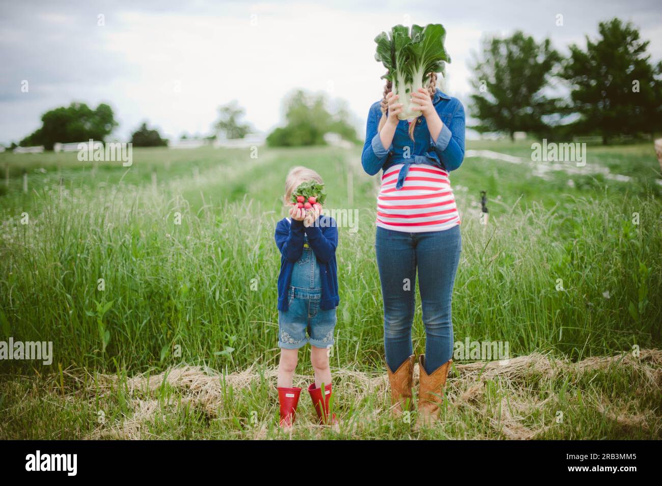 Due ragazze in una fattoria con i prodotti come faccia Foto Stock