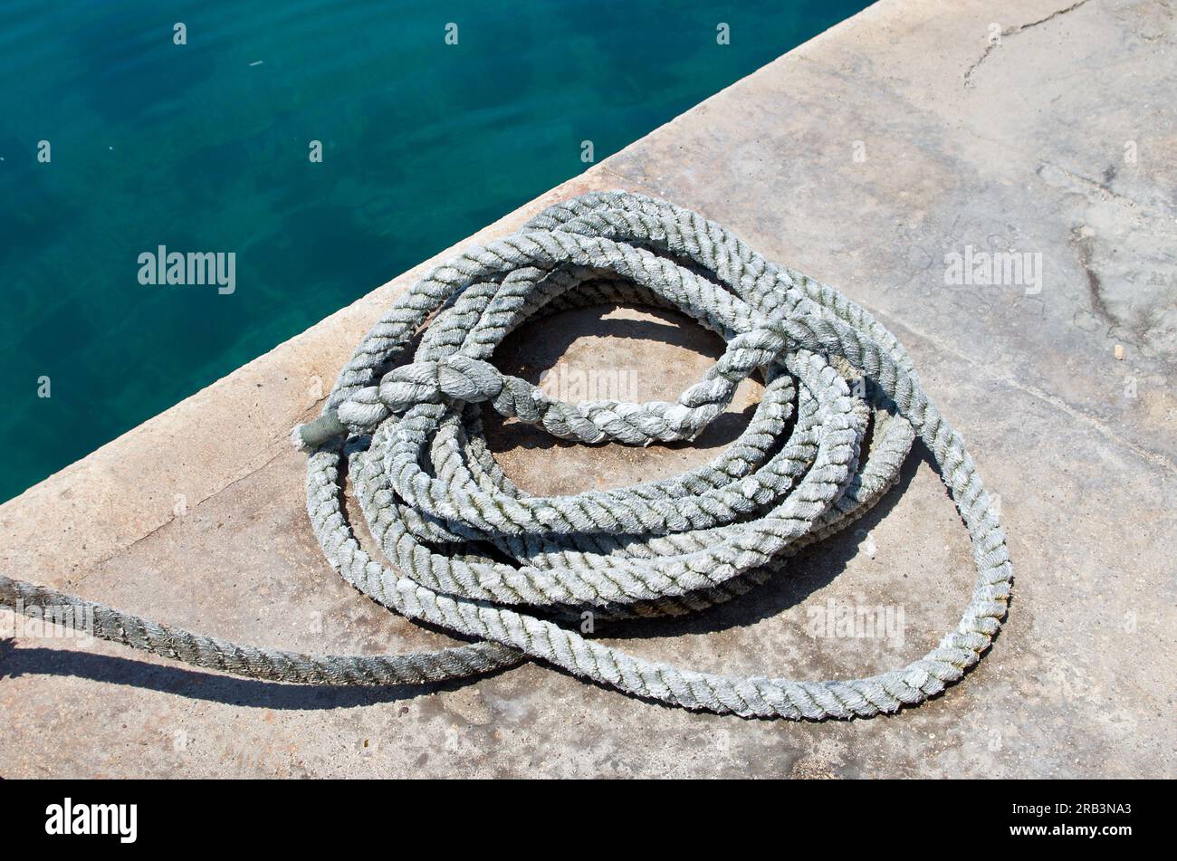 Un mucchio di corda per ormeggiare in una banchina sull'isola di Malta. Foto Stock