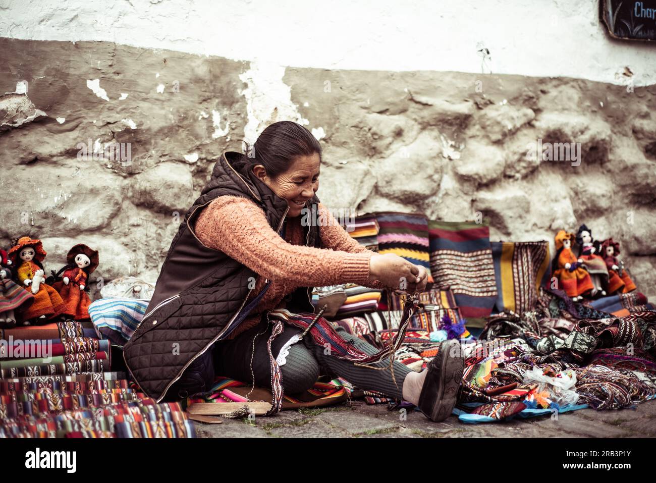 sorrisi e tessitori tradizionali locali seduti accanto alla strada in perù Foto Stock