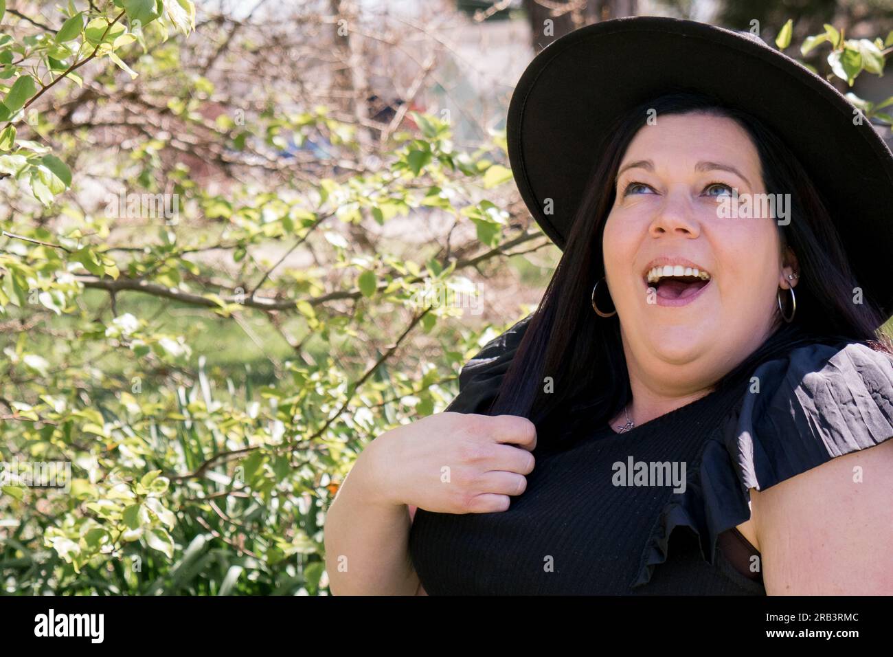 Chi io? Una bella foto primaverile di una signora che guarda in alto. Foto Stock