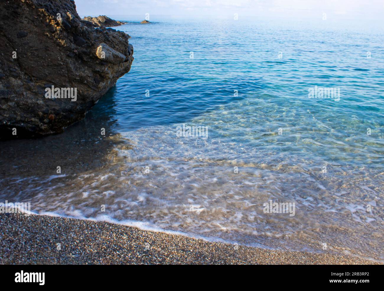 Blu, mare limpido ai Tropici. Stone Coast, Pebbles, riposa sulla spiaggia in un luogo ecologicamente pulito. Foto Stock