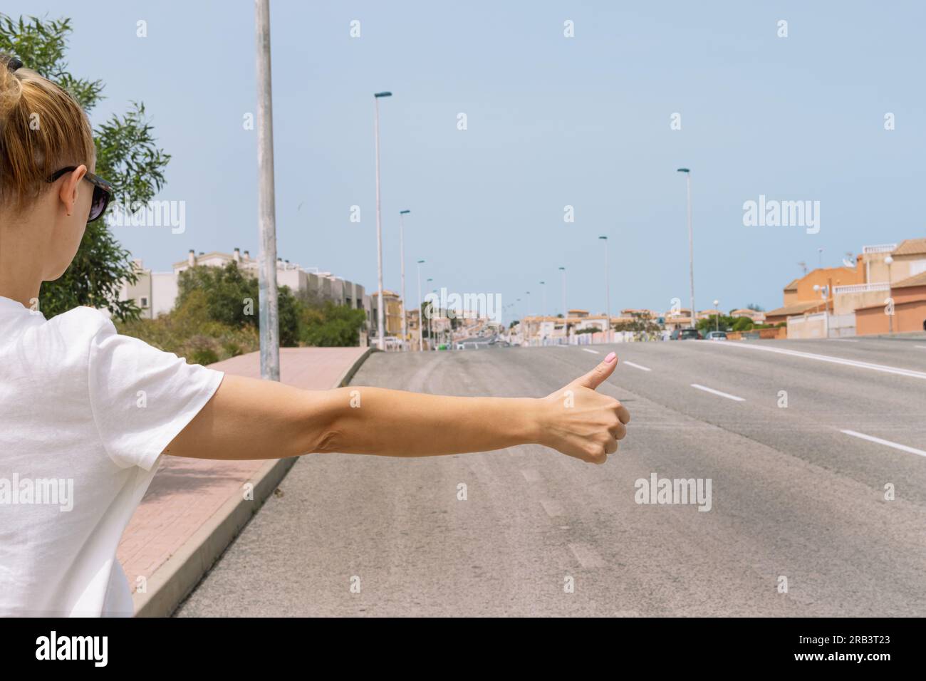 Una giovane donna prende un'auto in primo piano sulla strada con la mano, arresto automatico, frenata automatica, marcia, marcia. Foto di alta qualità Foto Stock