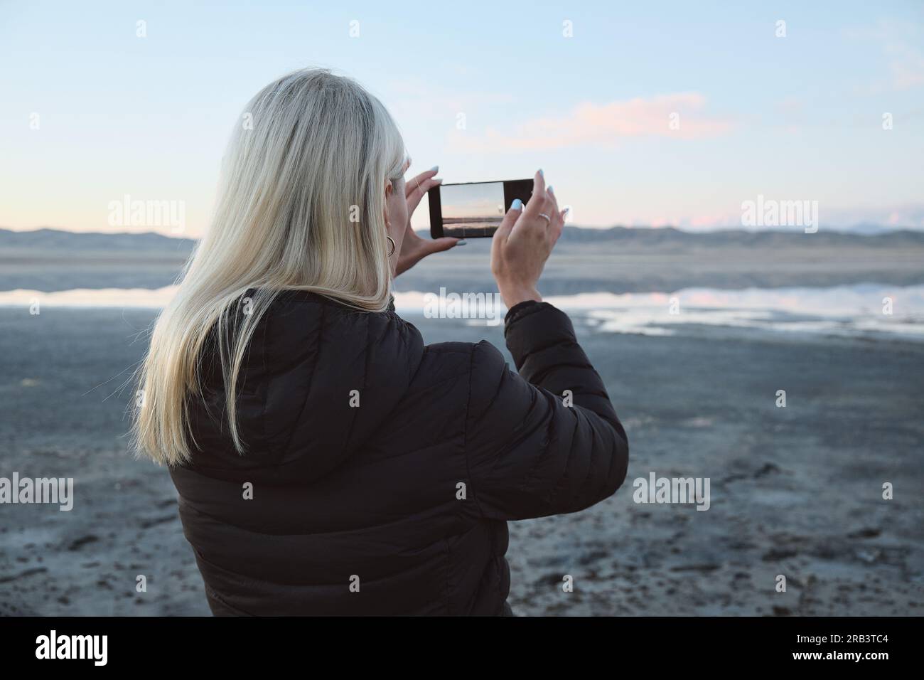 Mattina sul lago Tuz-Kol, Kazakhstan, una donna scatta una foto Foto Stock