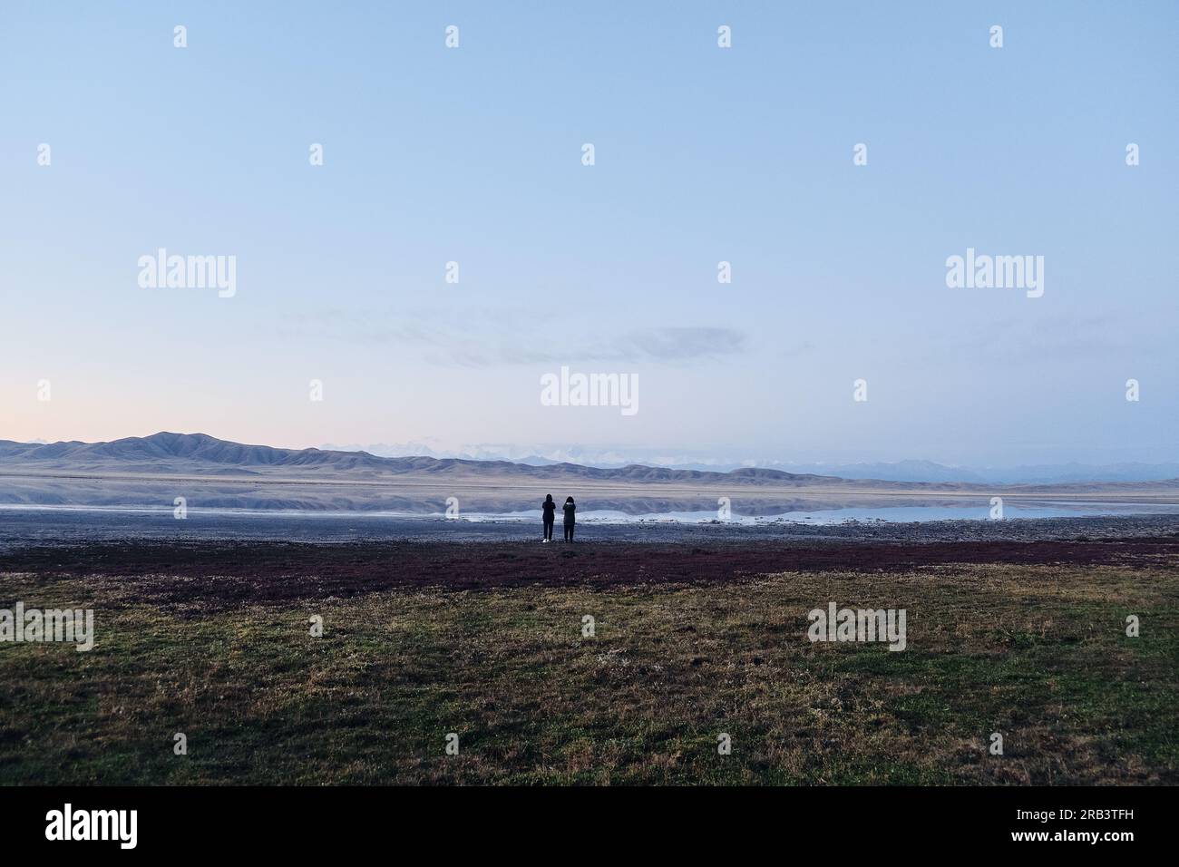 Due viaggiatori femminili ammirano il paesaggio mattutino, il grandangolo Foto Stock