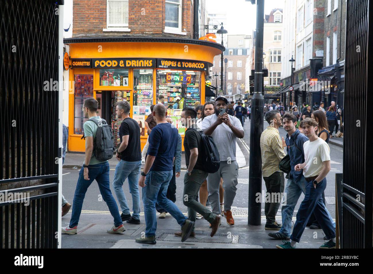 Meteo Regno Unito, 6 luglio 2023, Londra: Dopo alcuni giorni più freddi della media, il clima caldo torna a Londra, portando la folla a Soho. In Greeek Street i fumatori si soffermano mentre i pedoni passano di corsa. Crediti: Anna Watson/Alamy Live News Foto Stock