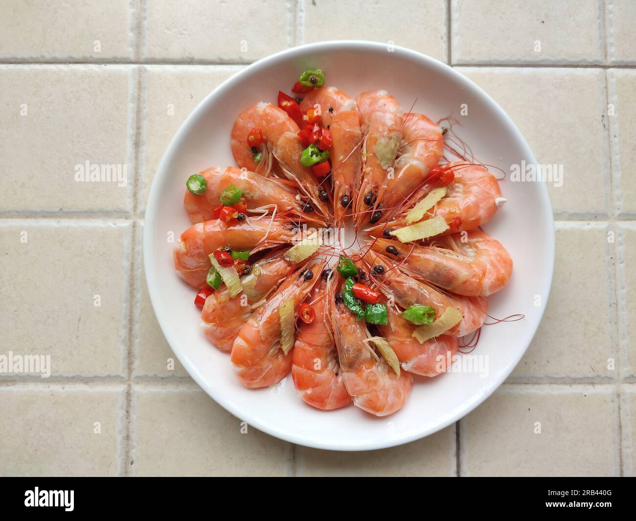 Gamberetti brasati freschi con peperoni verdi su un piatto Foto Stock