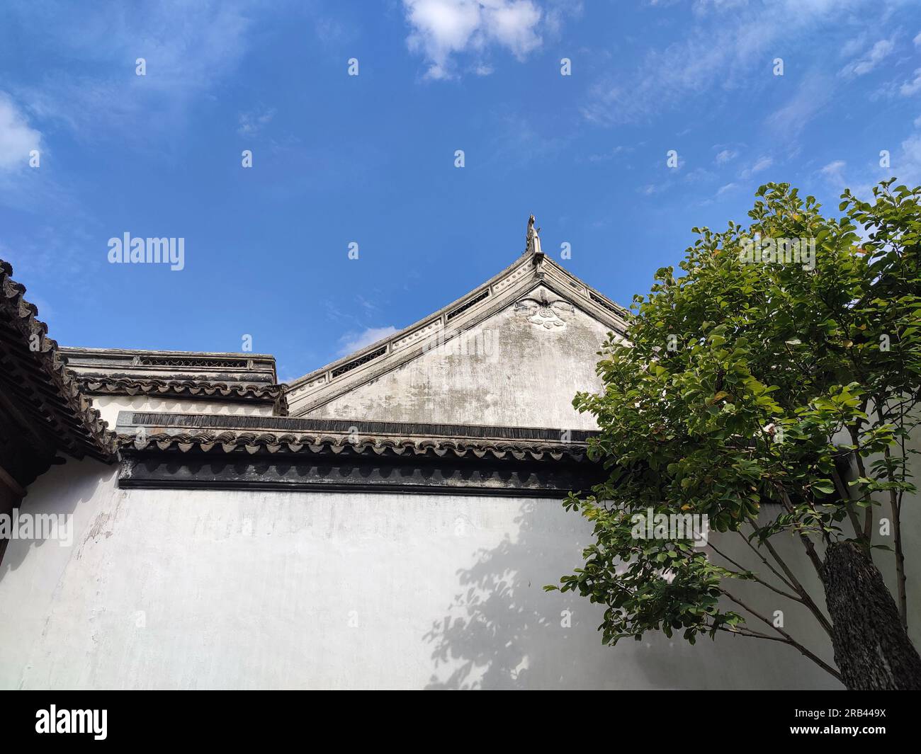 Antico architetto cinese con pareti bianche sotto il cielo blu nel pomeriggio soleggiato Foto Stock