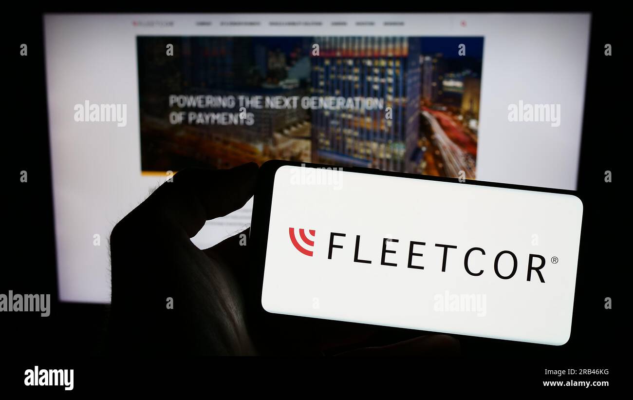 Persona che possiede uno smartphone con il logo della società finanziaria statunitense FLEETCOR Technologies Inc. Sullo schermo davanti al sito Web. Concentrarsi sul display del telefono. Foto Stock