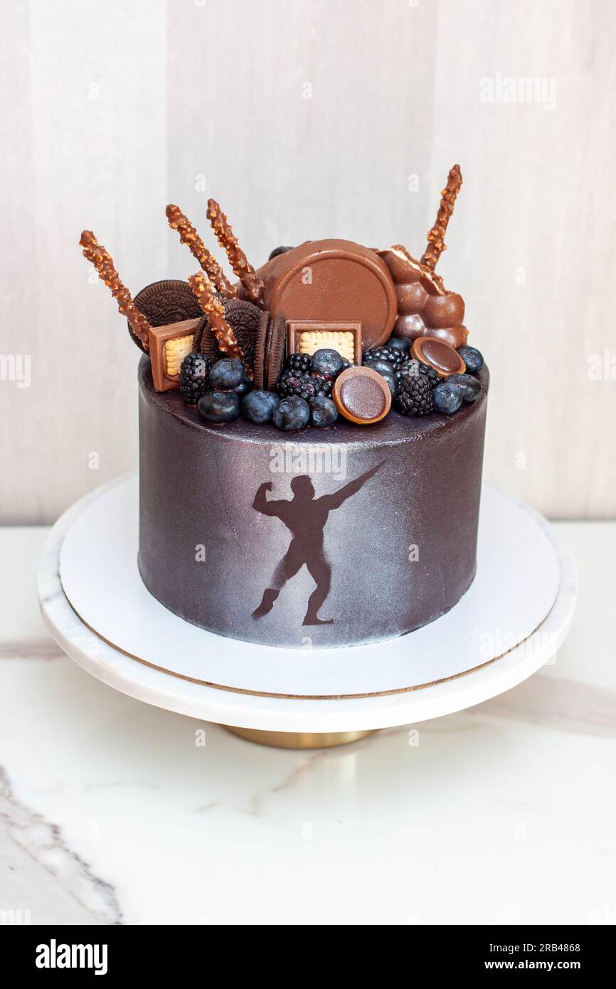 L'idea di una torta di compleanno per un bodybuilder, un atleta, un  sollevatore elettrico o un maratoneta. Torta decorata con frutti di bosco  freschi e cioccolato Foto stock - Alamy