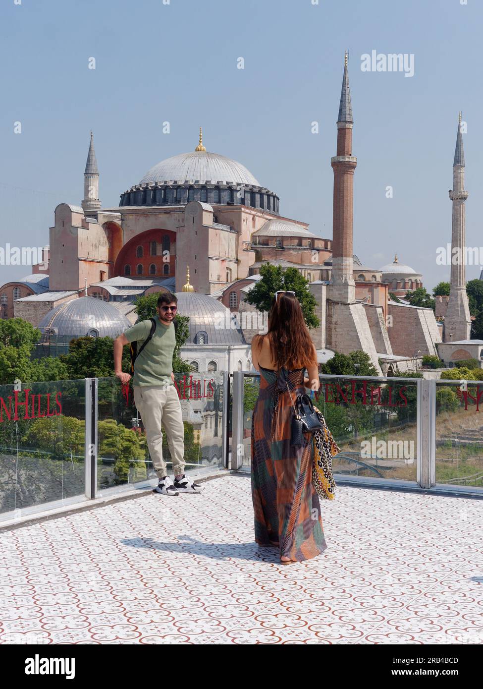 Due turisti apprezzano la vista dalla terrazza del ristorante Seven Hills verso la Moschea di Santa Sofia, Sultanahmet, Istanbul, Turchia Foto Stock