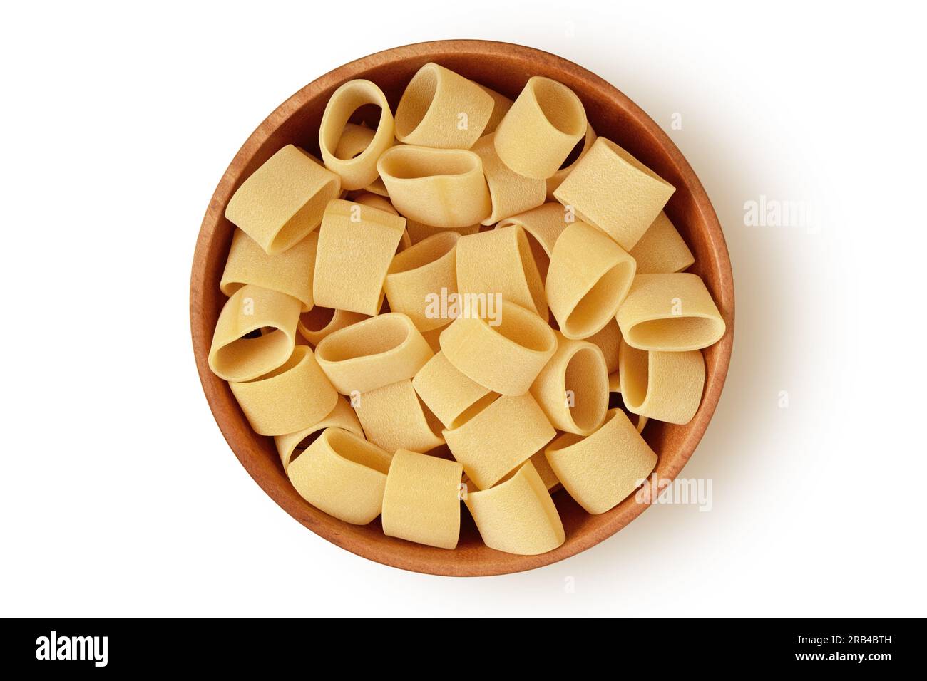 Pasta calamarata cruda in un recipiente di legno su sfondo bianco Foto Stock