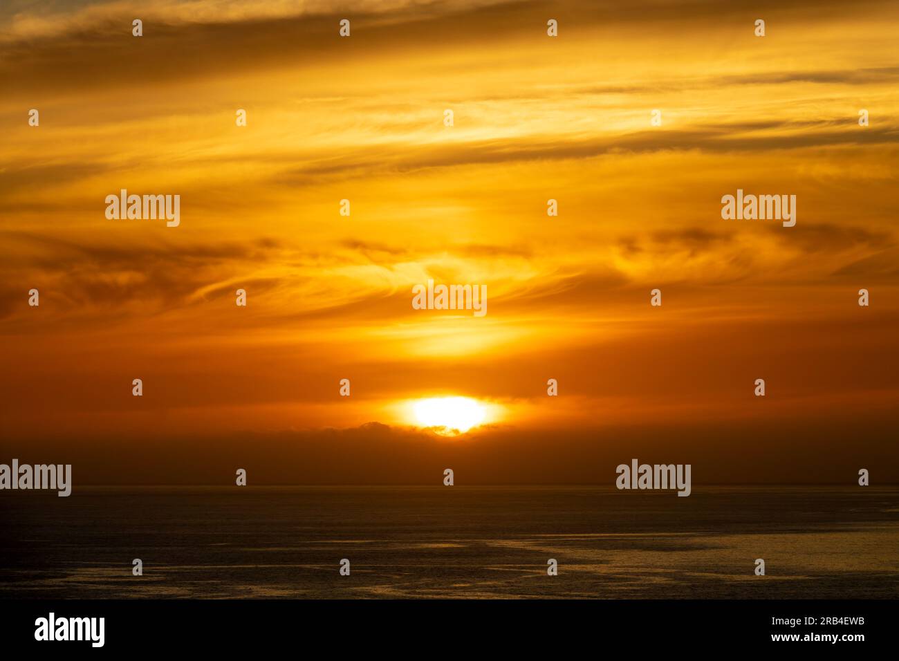 Cielo arancione con nuvole sull'oceano al tramonto sull'isola di Madeira, Portogallo Foto Stock