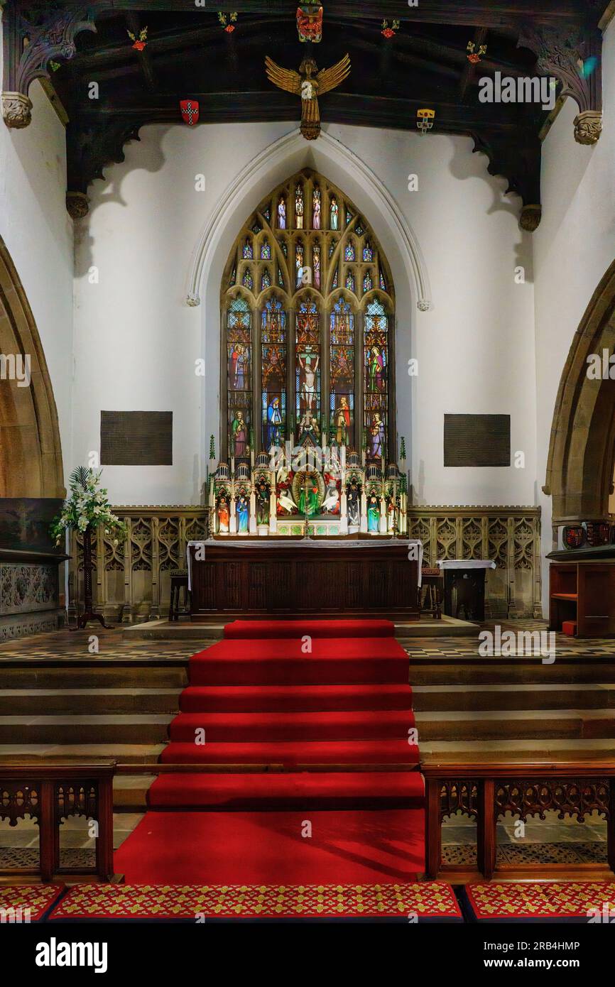 Skipton, North Yorkshire, la chiesa della Santissima Trinità dell'Inghilterra, vista dall'isola, completa di un tappeto rosso e di una spettacolare vetrata colorata. Foto Stock