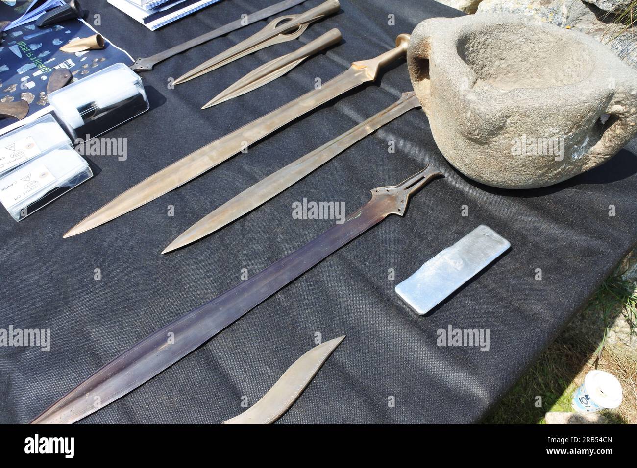 Riproduzione di spade, pugnali e coltelli dell'età del bronzo in una tavola di reperti in uno scavo archeologico a St Michael's Mount, Cornovaglia, Regno Unito - John Gollop Foto Stock