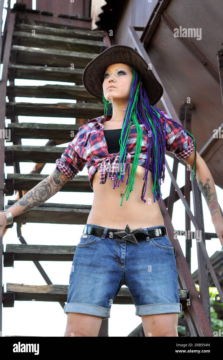 giovane donna tatuata ed elegante con dreadlock in stile contadino Foto Stock