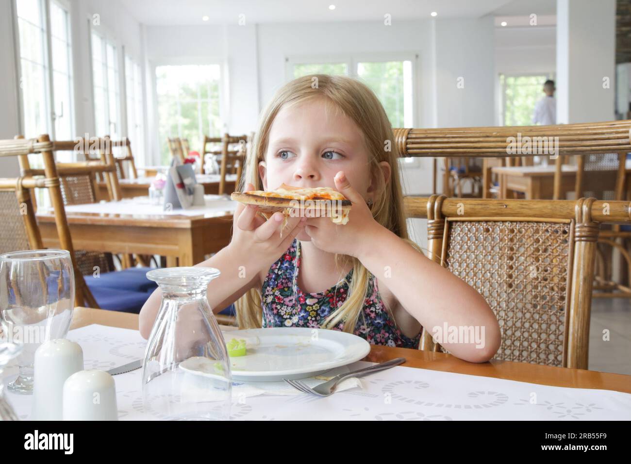Bambina che mangia pizza al ristorante Foto Stock