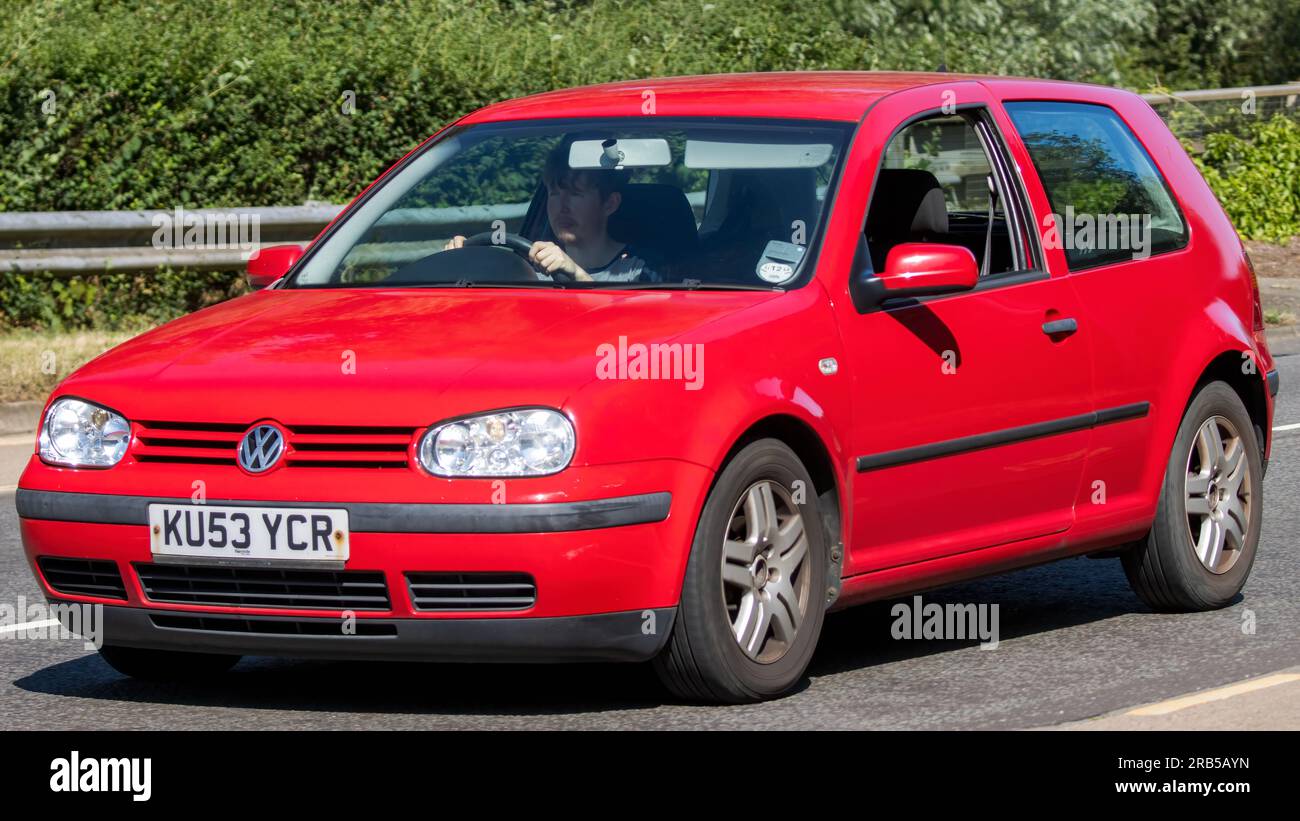 Milton Keynes, Regno Unito - 7 luglio 2023: 2003 auto da GOLF VOLKSWAGEN rossa che viaggia su una strada del Regno Unito Foto Stock