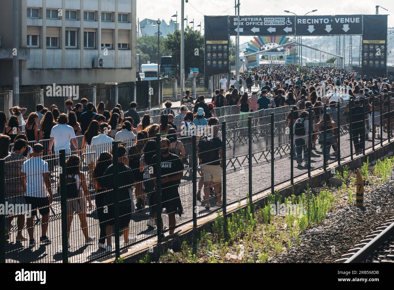 Lisbona, Portogallo - 7 luglio 2023: Una folla di persone cammina verso NOS Alive, uno dei festival di musica indie, rock e alternativa più rispettati d'Europa Foto Stock