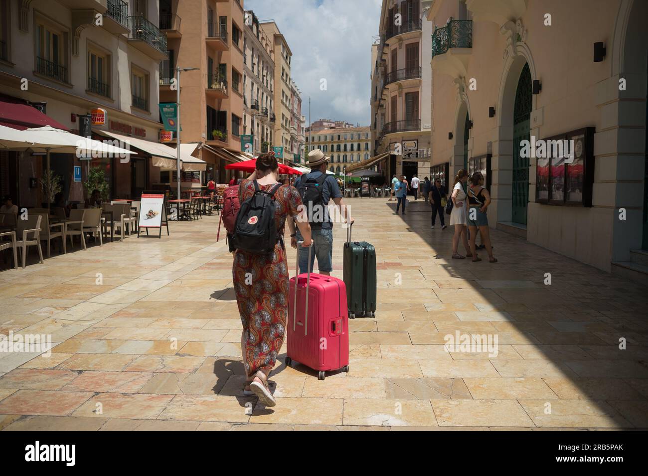 I turisti vengono visti spingere le valigie nel centro di Malaga. La Spagna ha registrato un numero record di visite turistiche internazionali durante i primi mesi dell'anno, così come un aumento nella spesa turistica loro denaro secondo l'Istituto Nazionale di statistica. Il turismo britannico continua ad essere uno dei più importanti in Spagna. Foto Stock