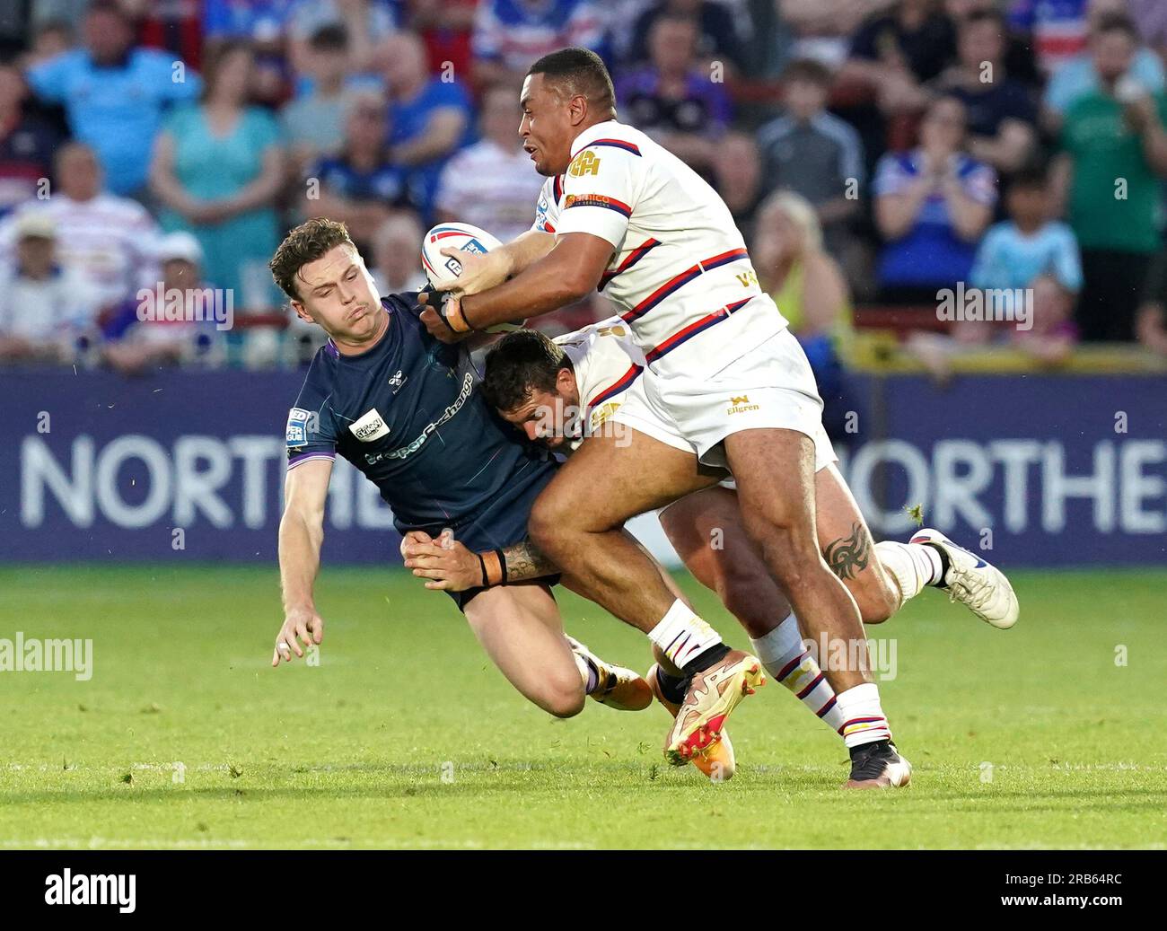 Il Jai Field dei Wigan Warriors fu placcato da Harry Bowes e Reece Lyne dei Wakefield Trinity durante il Betfred Super League match al Be Well Support Stadium di Wakefield. Data immagine: Venerdì 7 luglio 2023. Foto Stock