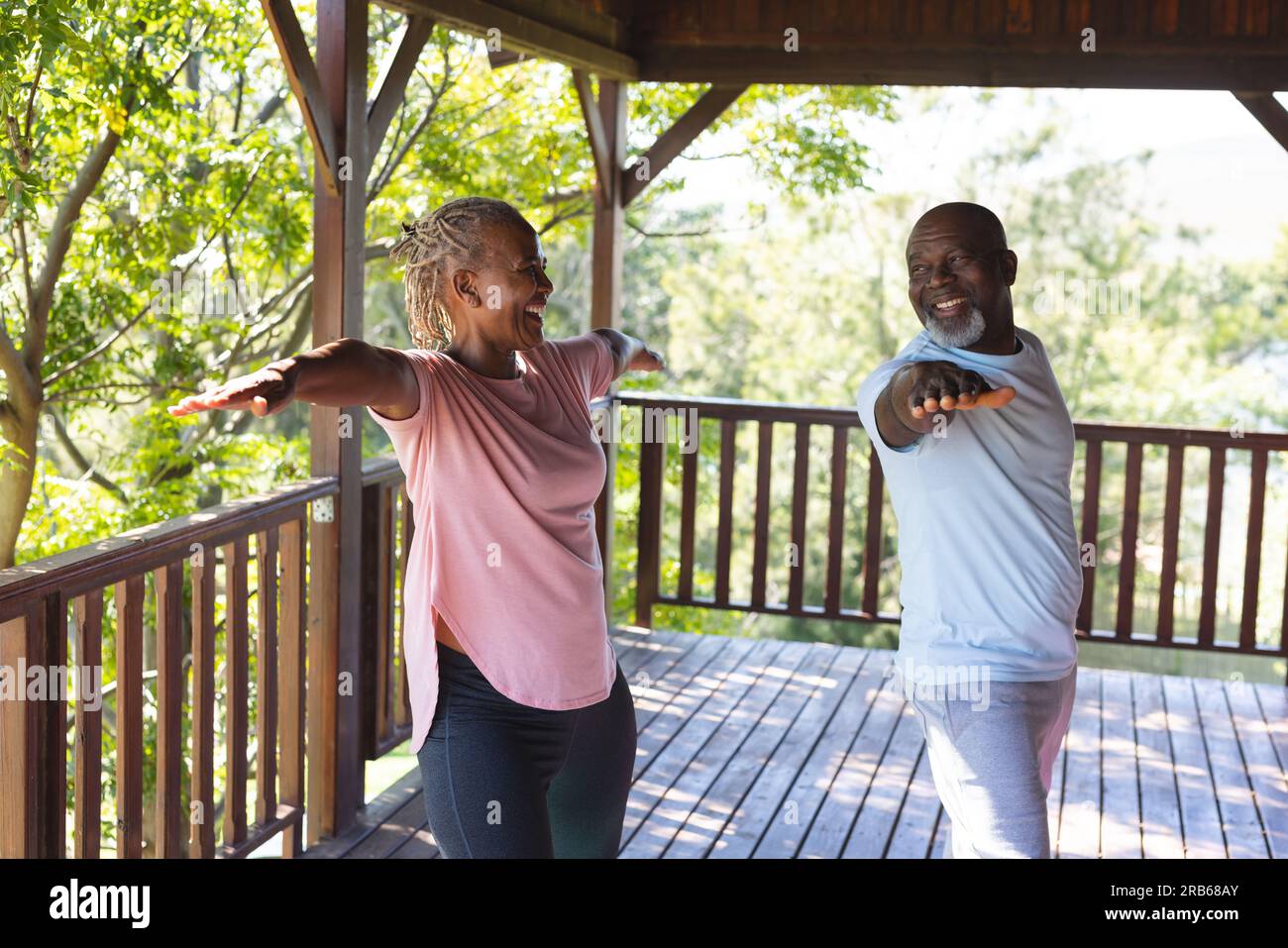 Felice coppia afro-americana che pratica yoga sulla terrazza. Senior lifestyle, relax, pensione, vita sana, fitness, esercizio fisico e benessere Foto Stock