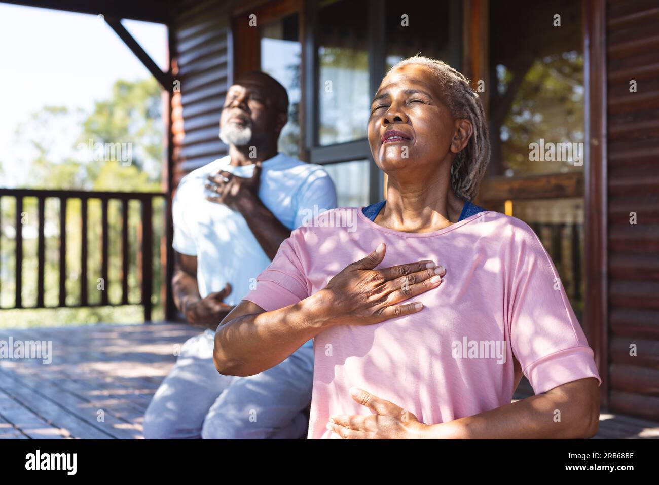 Coppie afroamericane anziane che praticano yoga sulla terrazza. Senior lifestyle, relax, pensione, vita sana, fitness, esercizio fisico e benessere Foto Stock