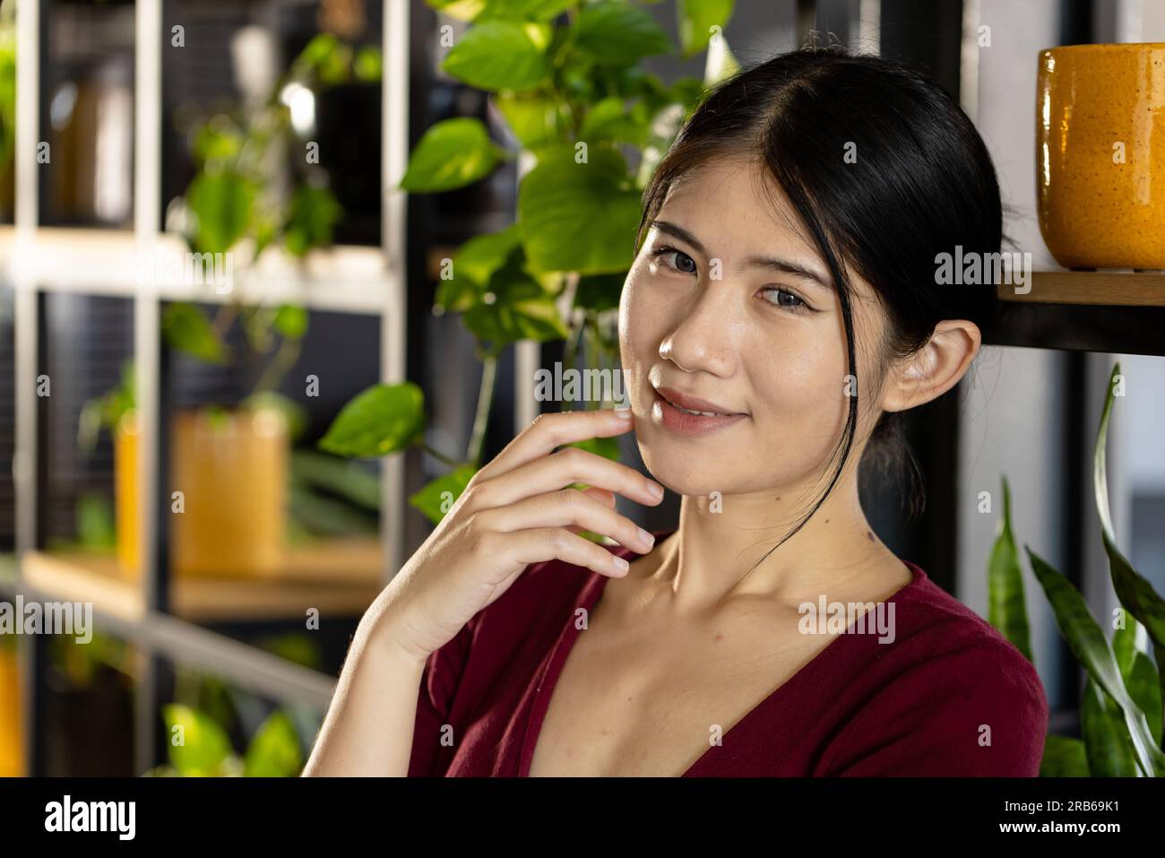 Ritratto di una donna d'affari asiatica informale e felice sorridente in ufficio. Lavoro, affari, fiducia, benessere e ufficio informale, inalterato. Foto Stock