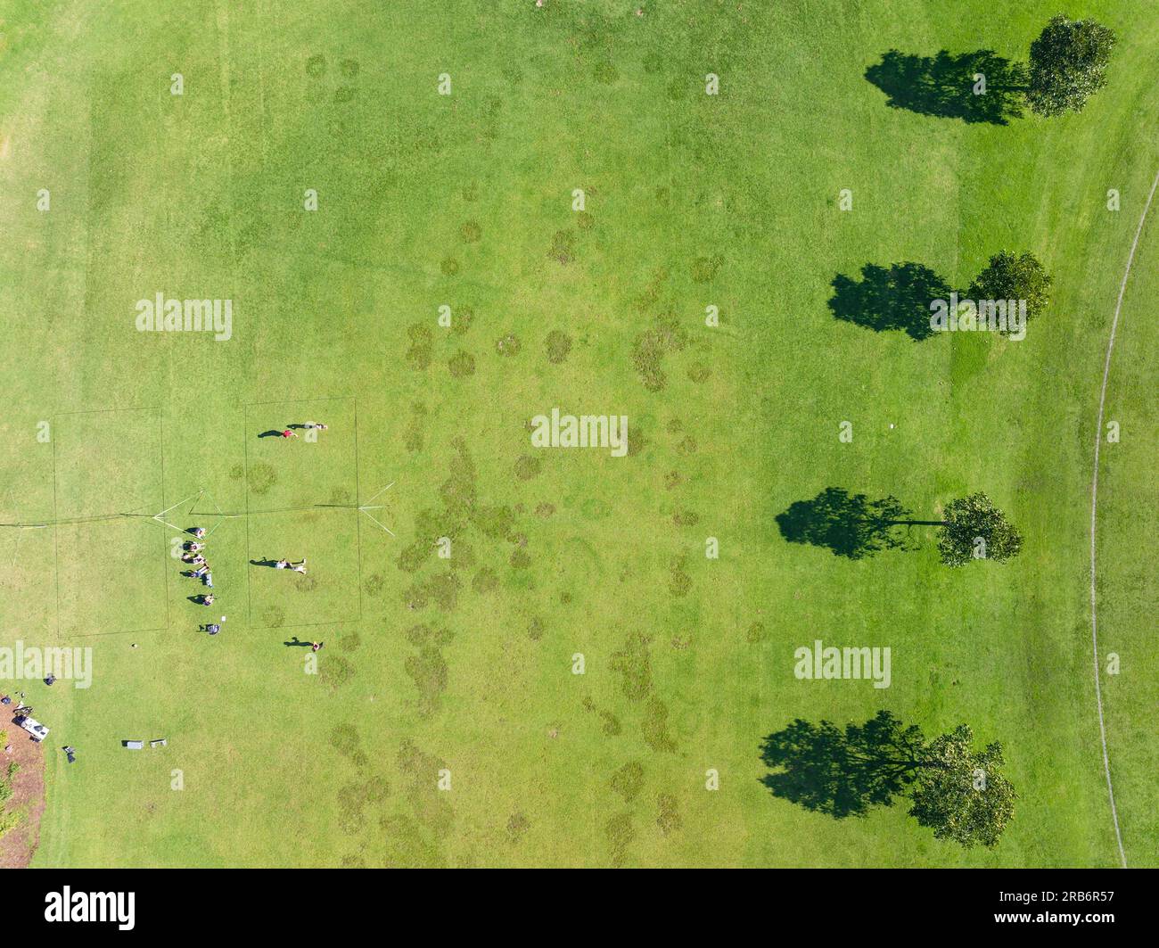 Vista aerea delle persone pf su un campo sportivo verde con alberi e le loro ombre al Carlton di Melbourne, Victoria, Australia Foto Stock