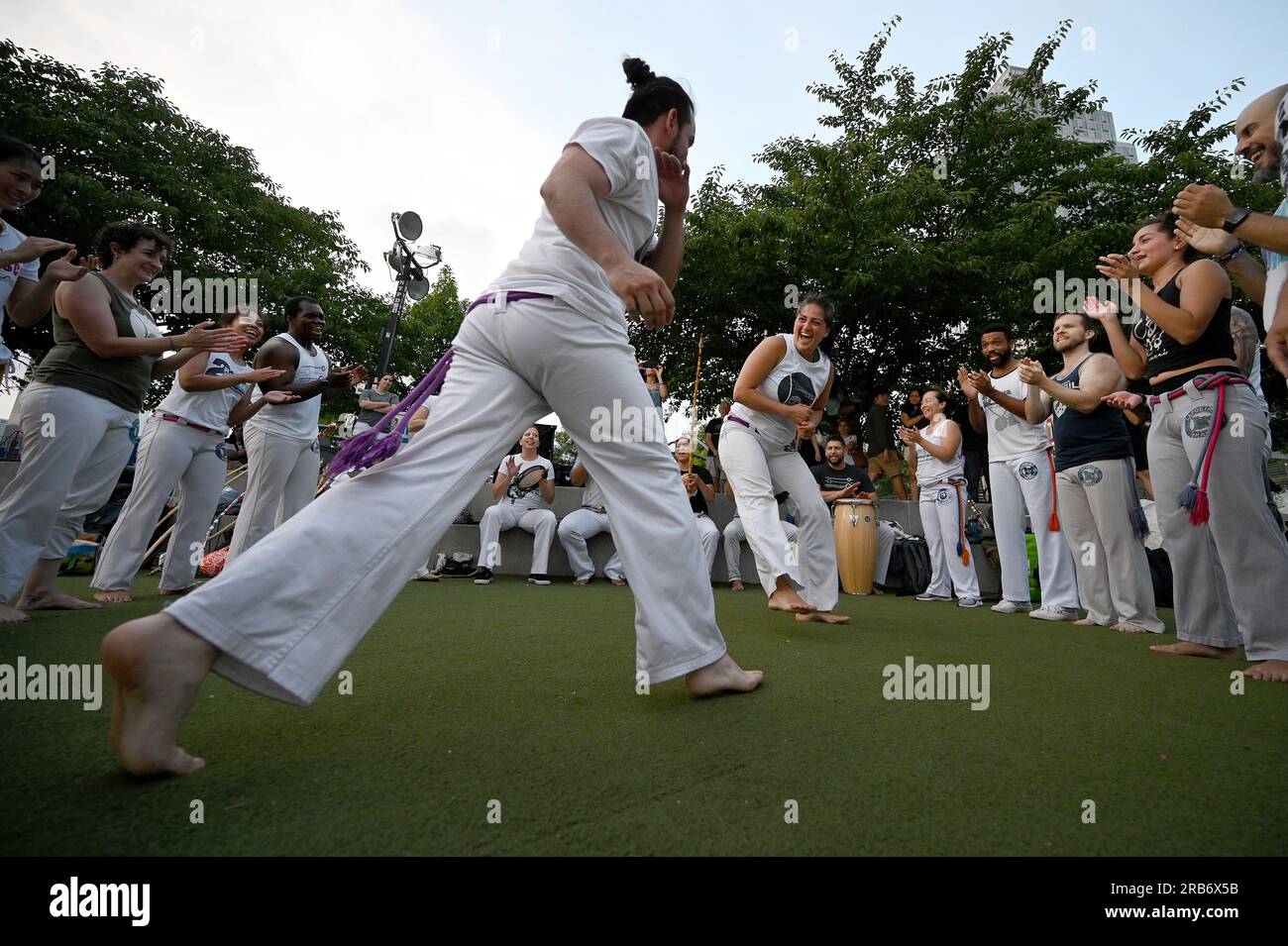 New York, USA. 7 luglio 2023. Un gruppo di persone esegue l'arte marziale afro-brasiliana di Capoeira a Hunter's Point South Park, nel quartiere Queens di New York, NY, il 7 luglio. 2023. Capoeira è un'arte marziale afro-brasiliana con elementi di danza e acrobazie Performd con musica. (Foto di Anthony Behar/Sipa USA) credito: SIPA USA/Alamy Live News Foto Stock