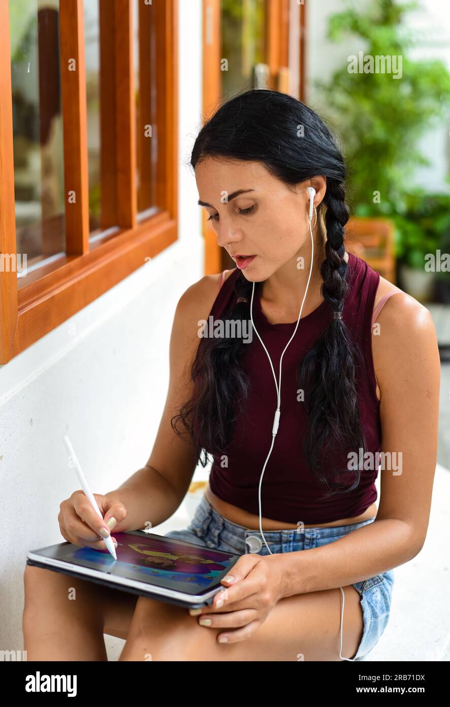 Bruna Ucraina illustratrice e artista che pensa al suo disegno elettronico nel tablet Foto Stock