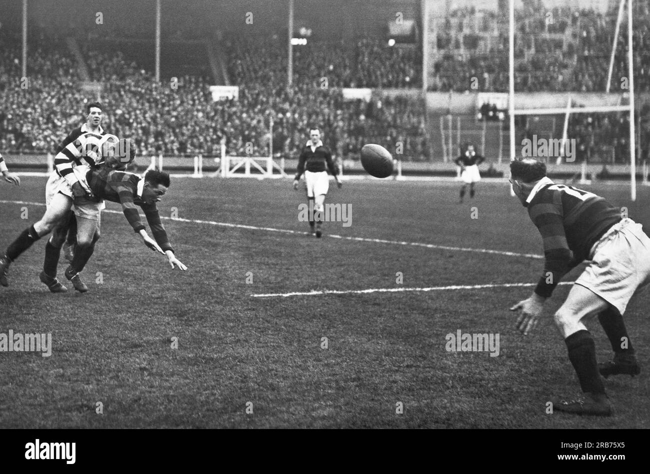 Londra, Inghilterra: 1929 per la prima volta nella storia, la finale di Rugby League Challenge Cup si è svolta al Wembley Stadium tra Wigan e Dewsbury. Qui un giocatore di Dewsbury passa a un compagno di squadra proprio mentre viene placcato. Foto Stock