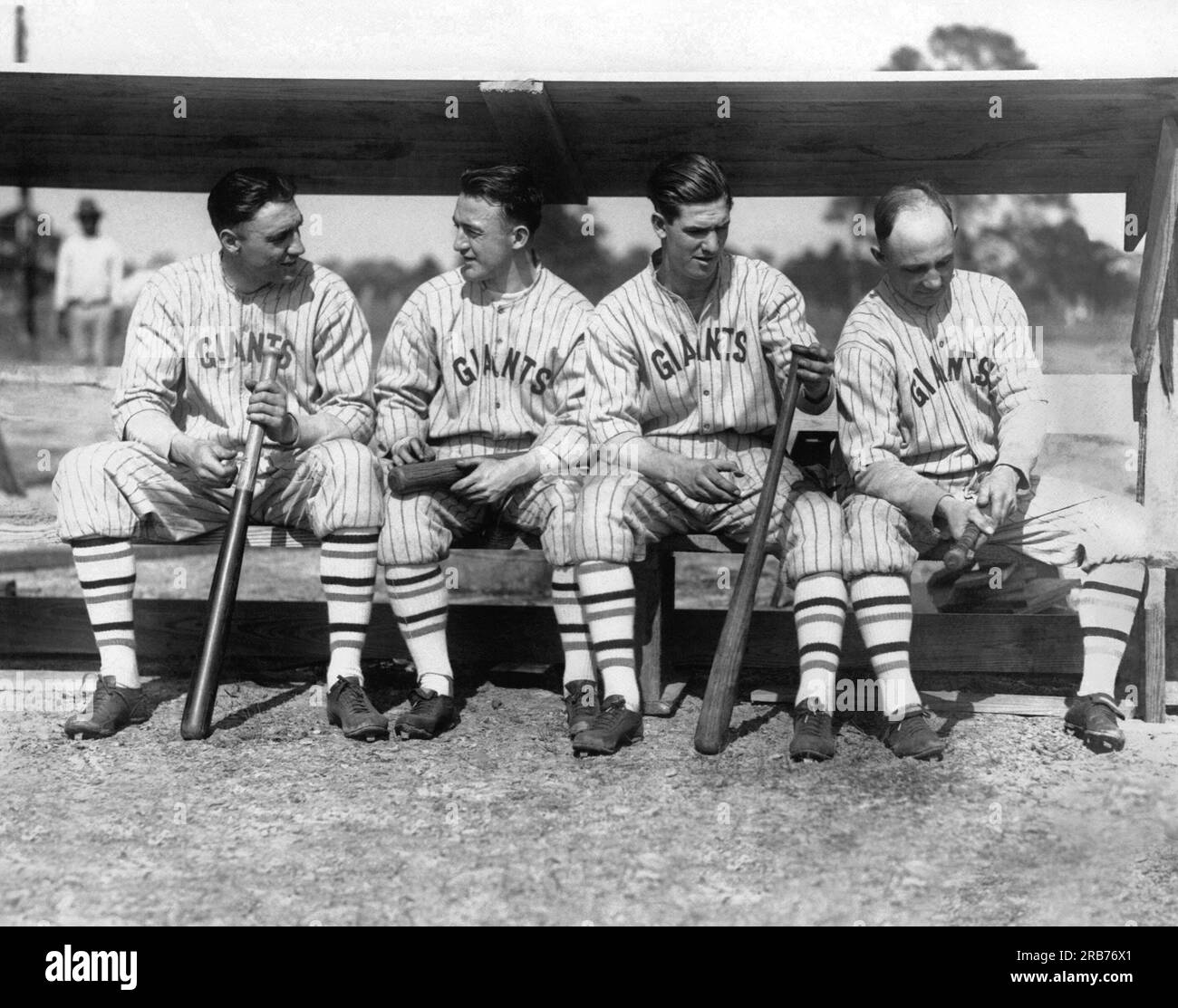 New York, New York: 1924 quattro membri della squadra di baseball dei New York Giants del 1924 seduti su una panchina che regge le loro mazze. L-R: George Kelly, Frankie Frisch, Travis Jackson, Heinie Groh. Foto Stock