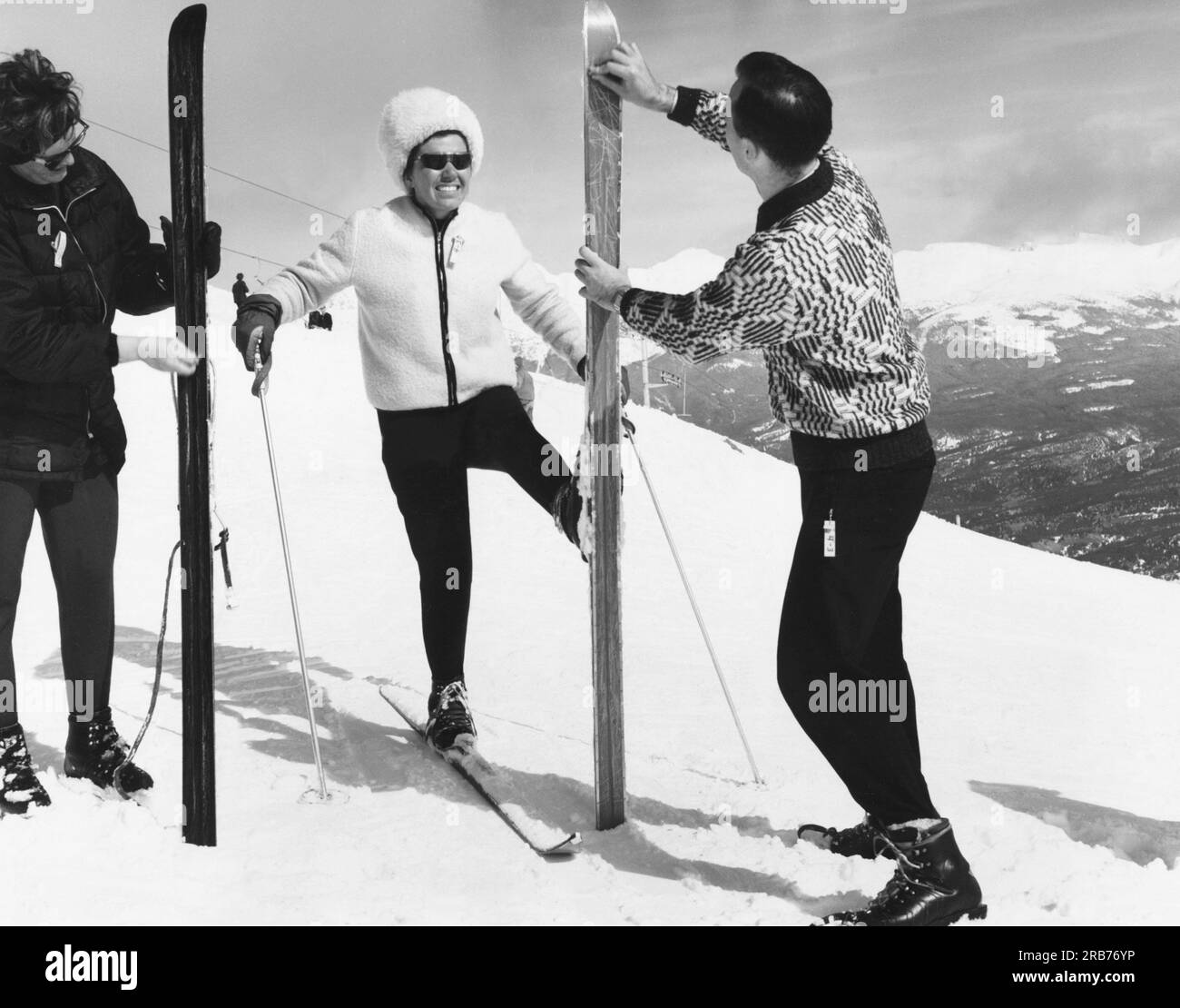 Parco nazionale di Jasper, Alberta, Canada: c. 1963 due donne vestono gli sci prima della corsa lungo la pista da sci. Foto Stock