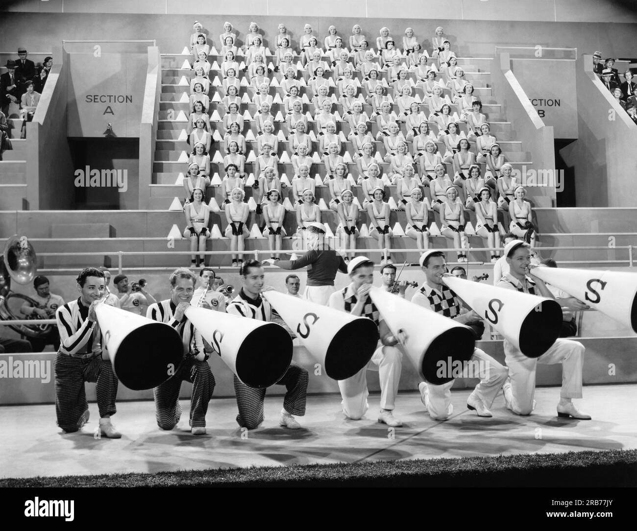 Hollywood, California: 1934 Una scena del film della Paramount, "College Rhythm" con uomini cheerleader che guidano gli All American Coeds. Foto Stock