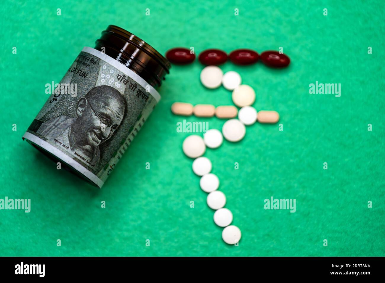 Questa foto mostra una bottiglia di medicina con note di 500 rupie indiane e pillole all'esterno. Le pillole sono disposte a forma di rupia indiana Foto Stock