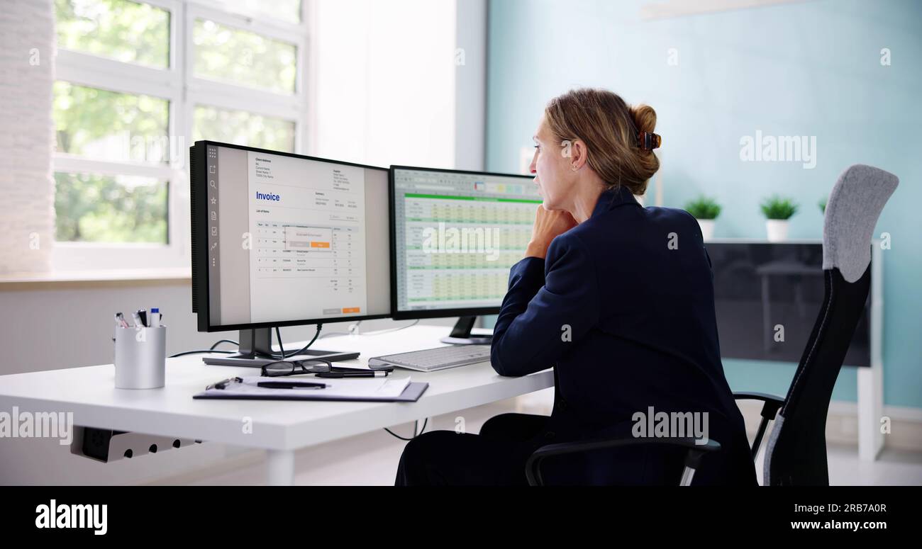 Contabile che utilizza il software e Invoice presso il computer in ufficio Foto Stock