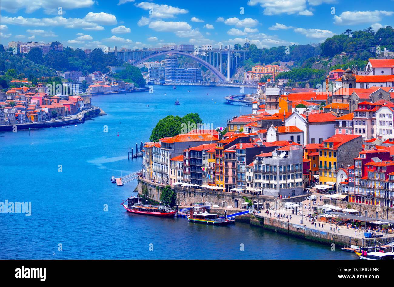 Vista della storica città di Porto con la vecchia architettura tradizionale, il fiume Douro e il ponte di Arrabida in lontananza in una giornata di sole in Portogallo Foto Stock