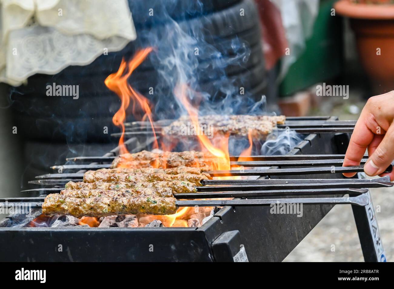 Spiedini speziati con fiamma, la carne macinata sugli spiedini viene cotta alla griglia Foto Stock