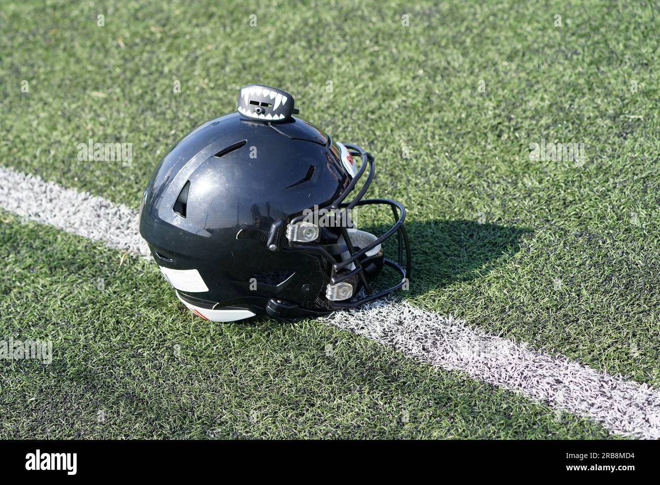 Casco da football americano su erba con scudo gengivale sulla parte superiore Foto Stock