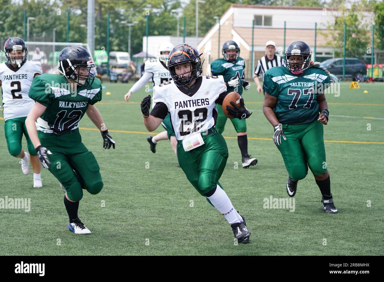 Una giocatrice di football americano che corre con la palla Foto Stock