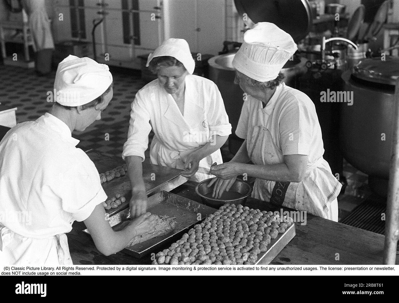 Il grande magazzino NK di Stoccolma nel 1954. Ecco una foto della cucina del grande magazzino dove cucinano per il loro personale. Questo giorno, le polpette sono nel menu, 8.000 pezzi devono essere fatti e sembra che vada bene e tre si aiutino a vicenda con il monotono lavoro di modellare le polpette alla stessa dimensione. Svezia 1954. Kristoffersson rif. 2A-33 Foto Stock